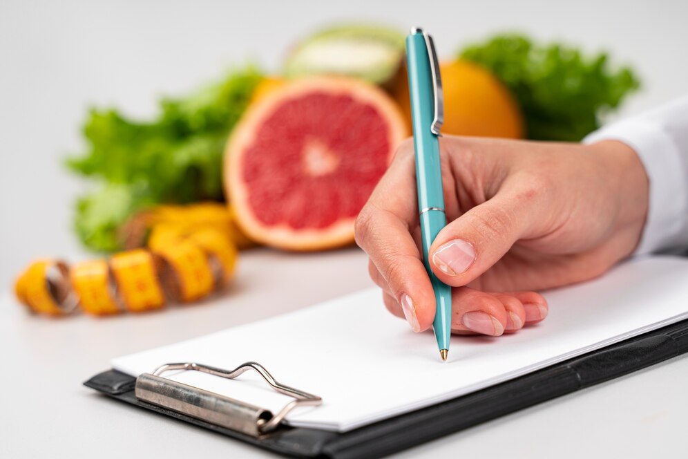 A woman’s hand writing meal plans during a nutrition advice visit.
Source: Freepik