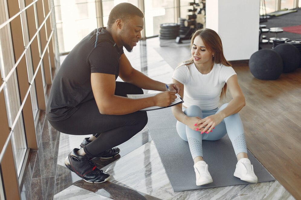 A personal trainer involved in best relation with his client, making a detailed plan of cooperation.
Source: Freepik