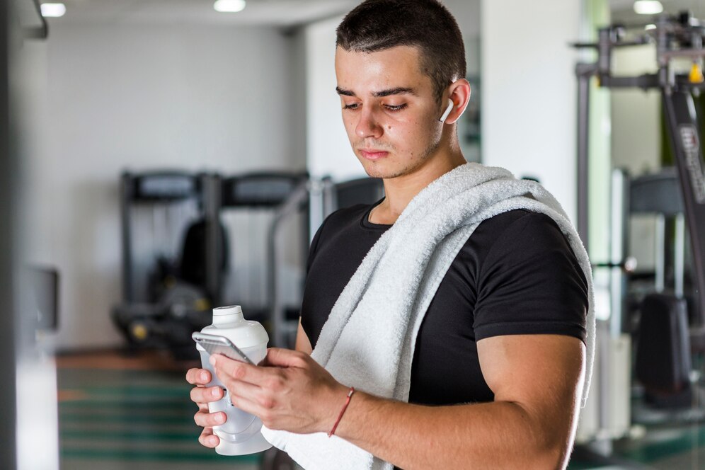 A young personal trainer checking the app during a break from training.
Source: Freepik