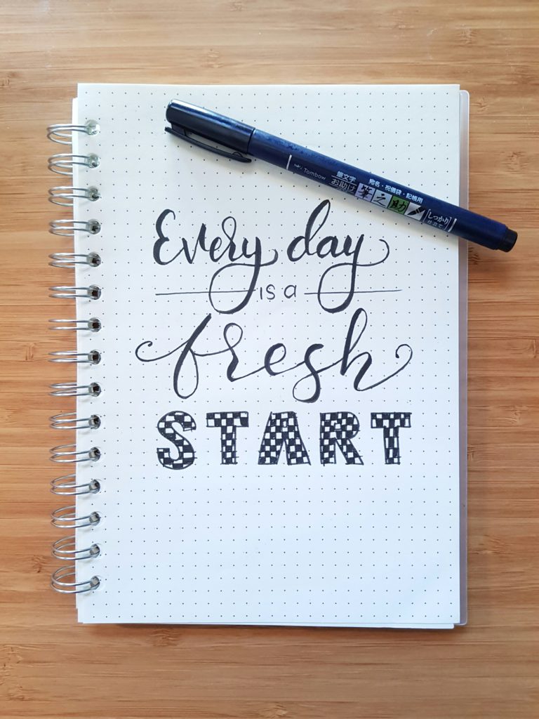 “Every day is a fresh start” written in a notebook - a motivational quote for a good day’s beginning.
