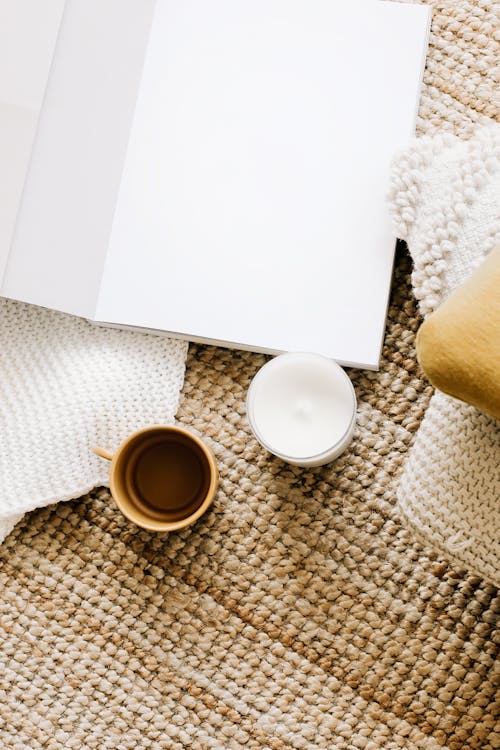 Items on a carpet: coffee, milk and an empty notebook without any ideas for a gym name.