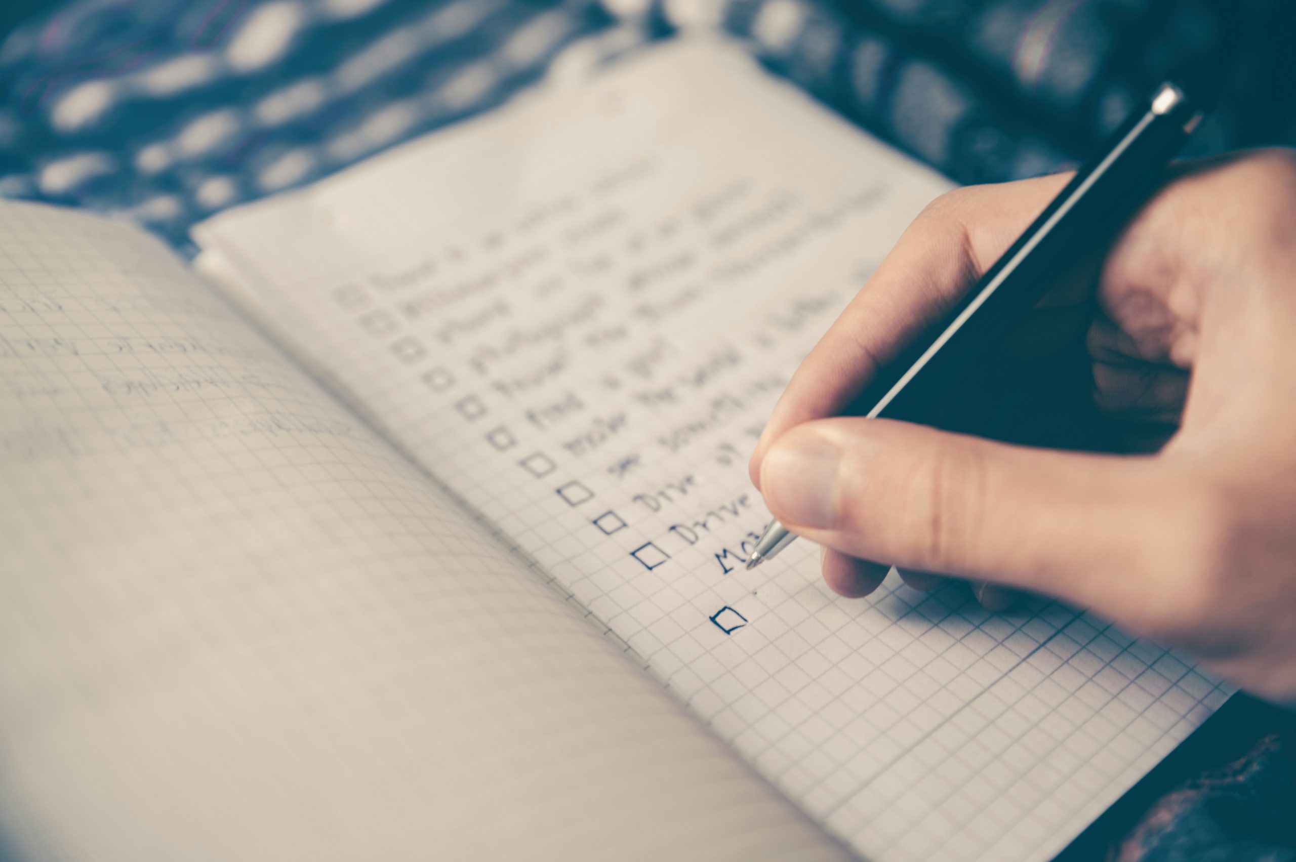 Writing notes connected with a dance business, in a checked notebook.