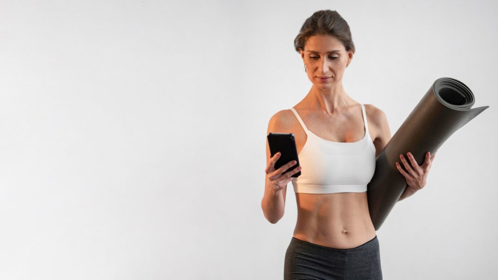 A fitness woman managing her fitness center via phone. Source: Freepik