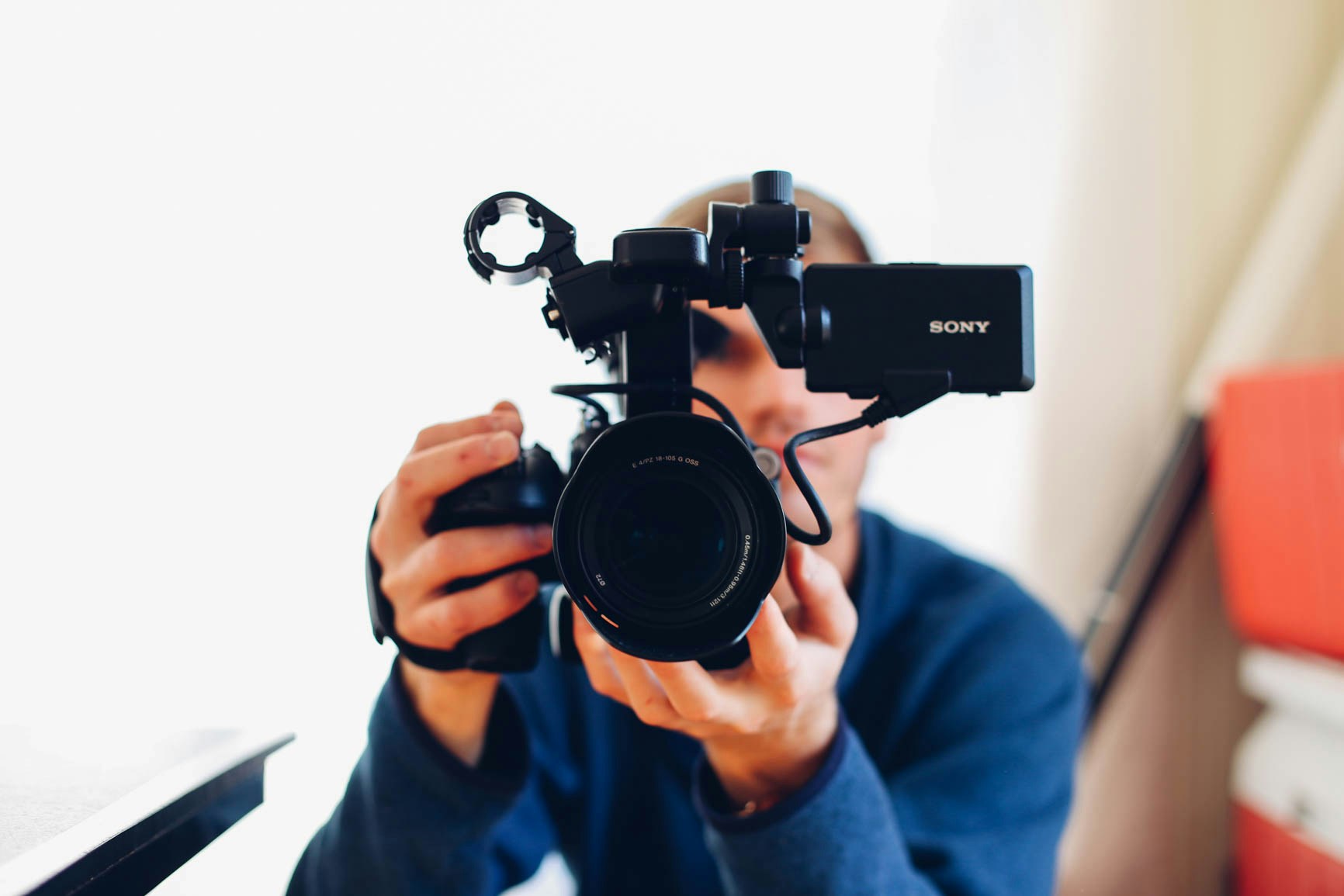 A person holding a camera pointing at you, recording a marketing spot which promotes your martial arts business.