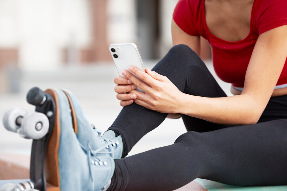 A young woman taking pictures of her roller skates to use an app idea of an in-app purchase.