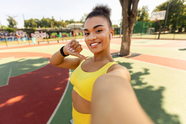 Fitness influencer taking a selfie on an outdoor running track.