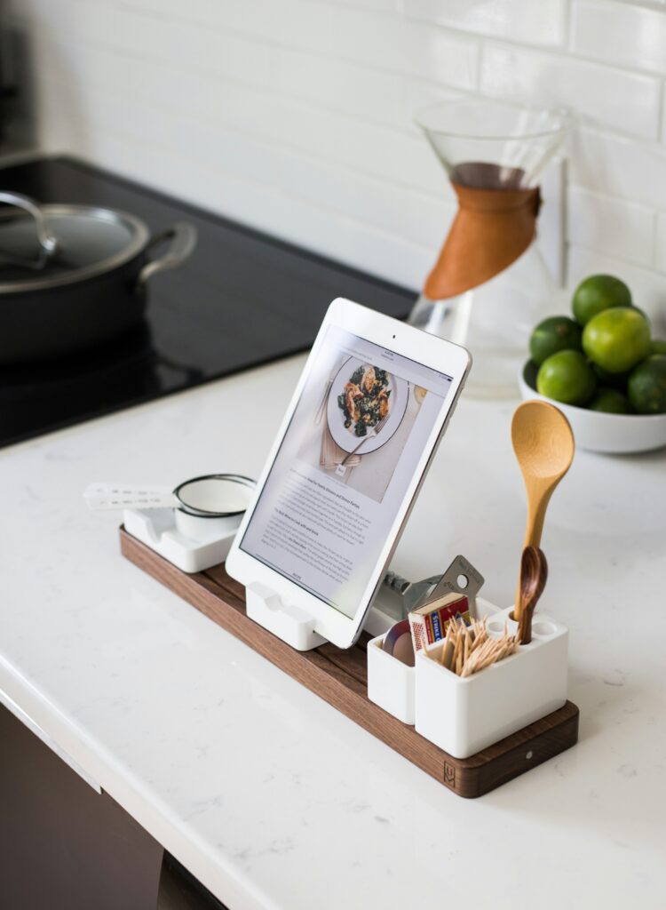 A kitchen counter and table on which a recipe for healthy food is displayed, provided by social media channels of a subscribed gym.