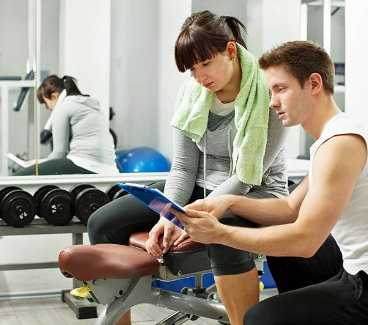 A fitness consultant helping gym members achieve their fitness goals.