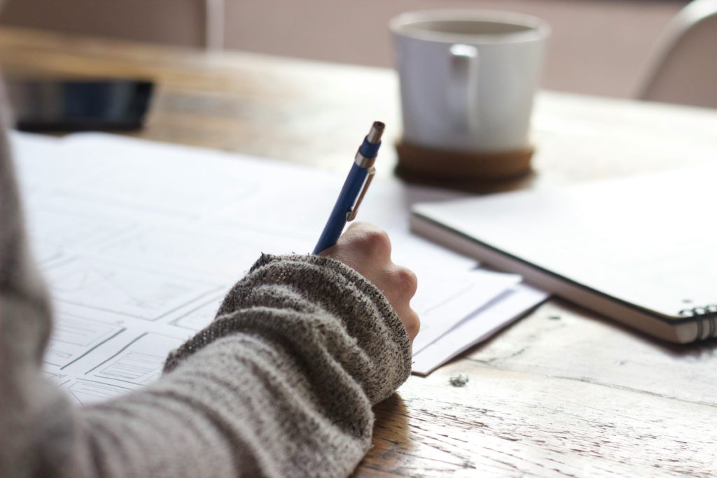 A person filling many documents carefully in order to receive a grant.