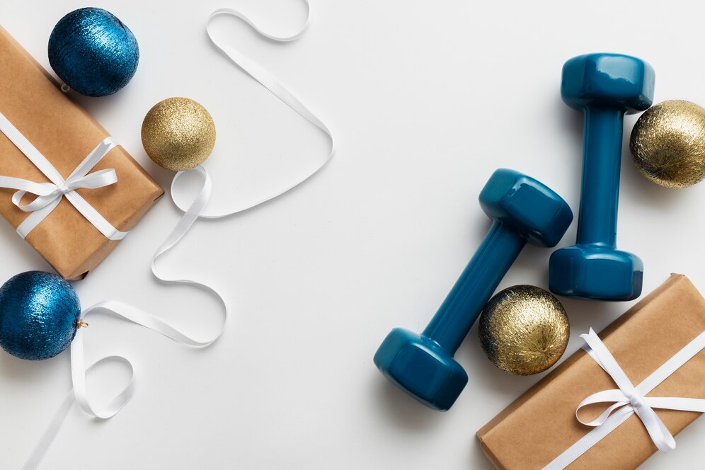 Blue dumbbells and Christmas items representing the idea of a fitness service as a gift.