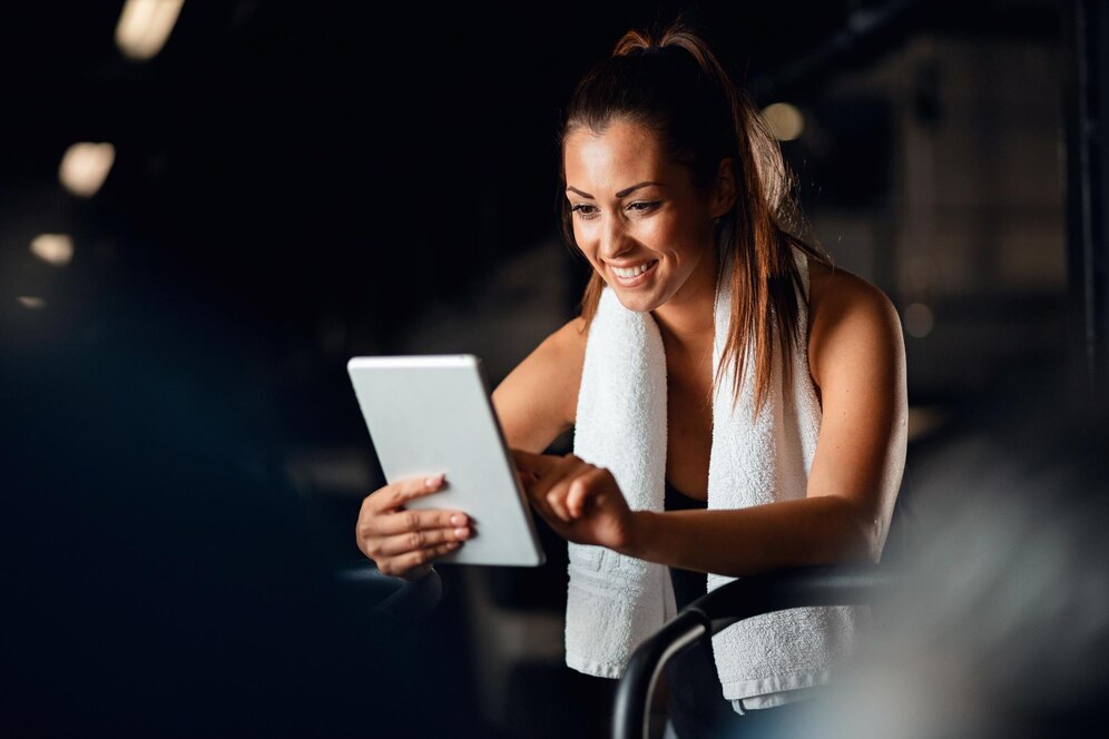 A woman after her training using fitness software on her tablet. Source: Freepik