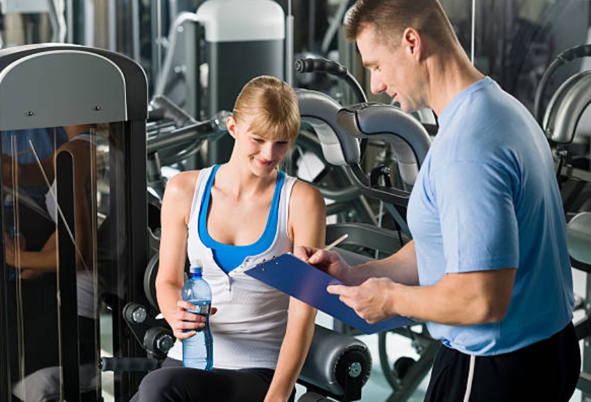 A fitness consultant explaining to a gym member the details of her personal training.