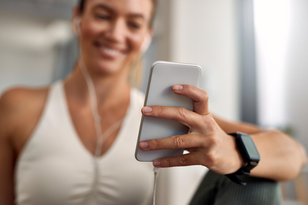 A satisfied young woman using the friendly interface of a fitness app.