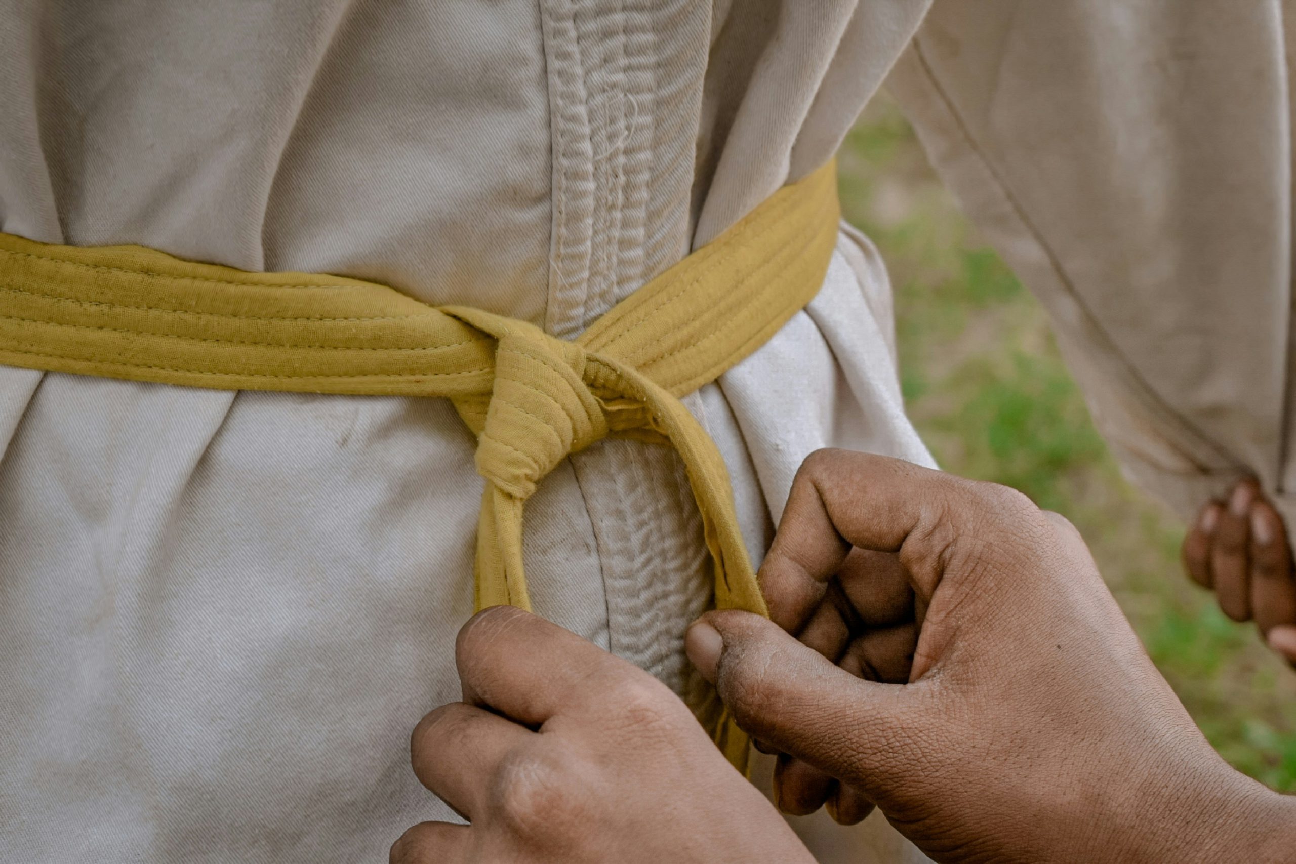 Martial arts classes - an instructor tying a student's belt.
