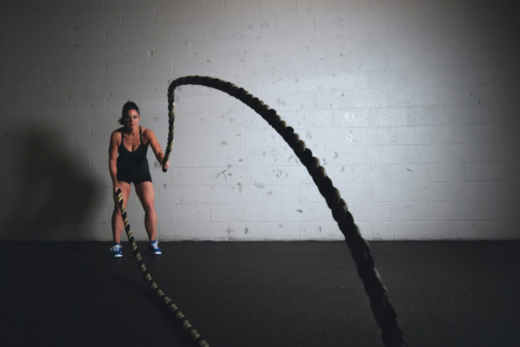 A woman practicing with battle ropes.