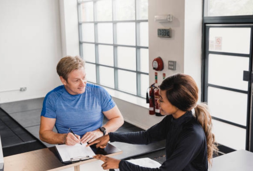 Gym staff working on fitness classes gym membership contracts, including payment schedule and emergency contact information.