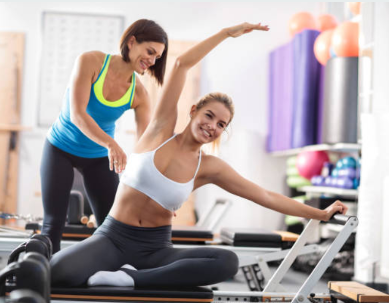 Pilates instructor at work with her student.