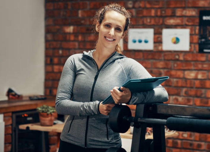 A gym manager next to some exercise equipment.