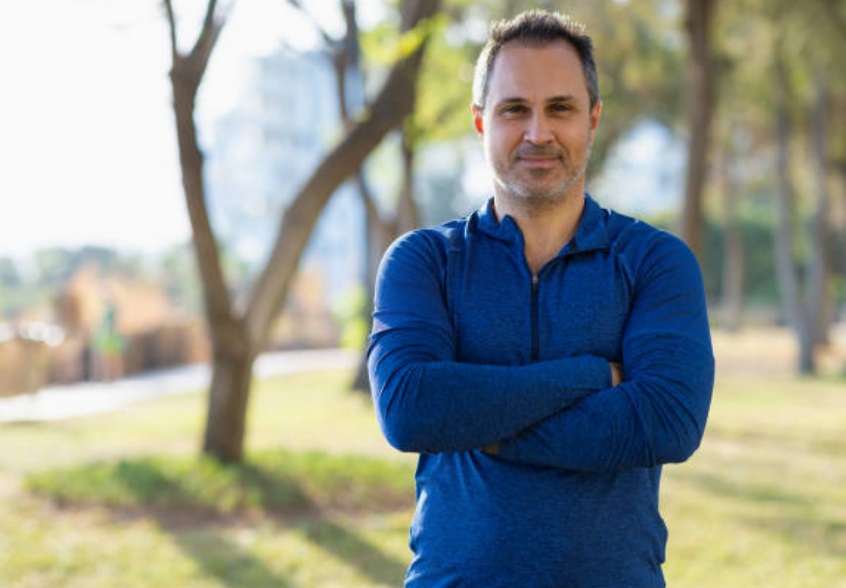 A personal trainer, running a mobile fitness business, waiting for his clients in a park.