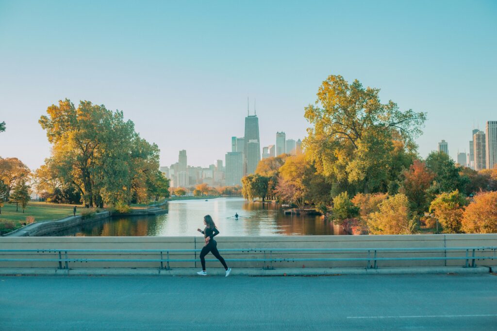 A woman jogging on a bridge as an example of personal health care and disease control.