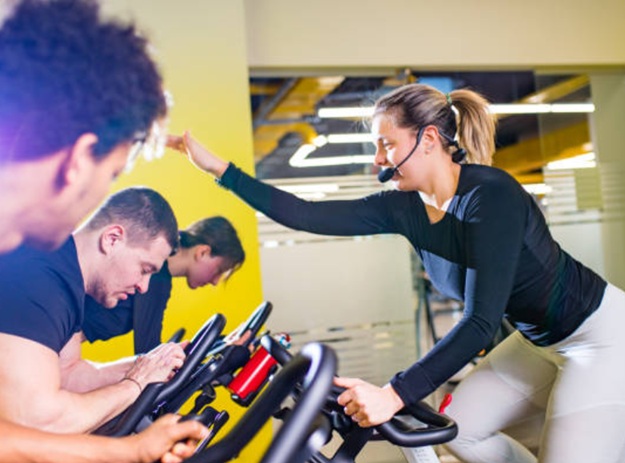 Spin classes in a specialized fitness studio: fitness enthusiasts with the cycling studio owner or trainer.