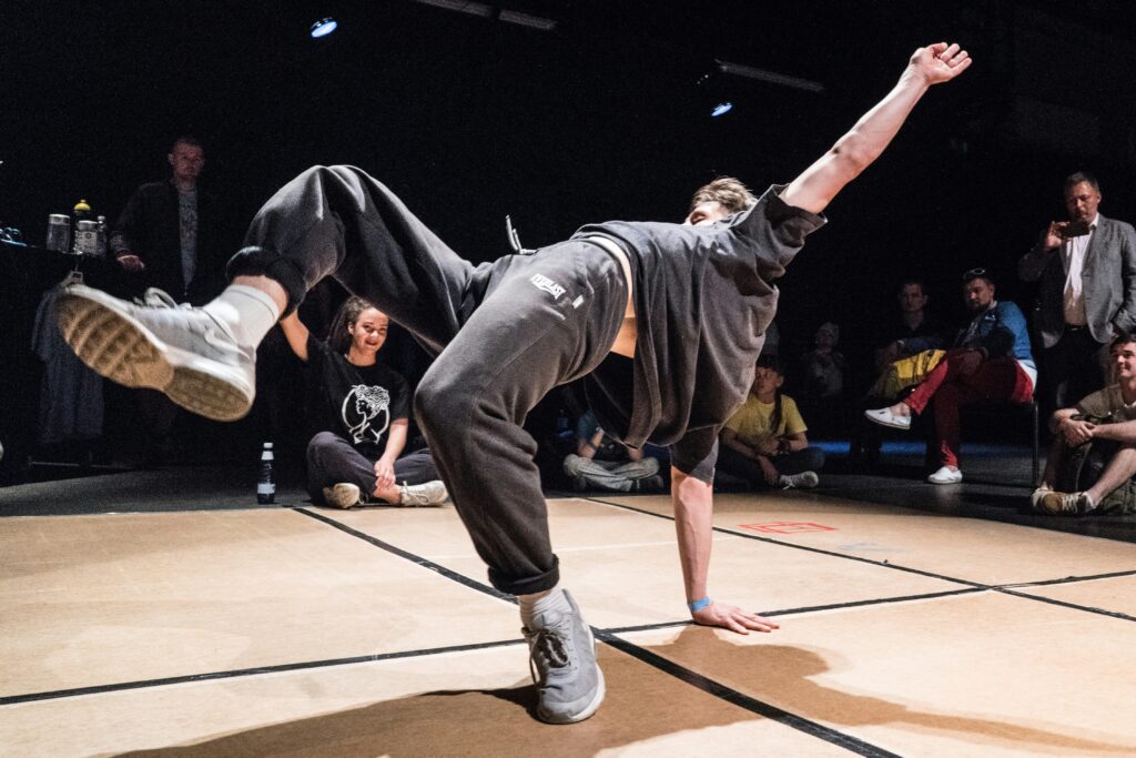 Hip hop dance instructor showing dance choreography moves to his students.