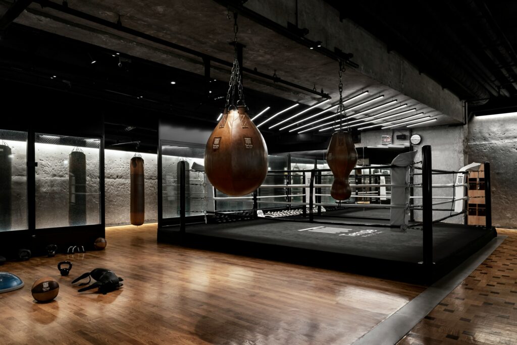 Gym interior design ideas may be various: here a dark minimalist and elegant style without workout equipment, but with boxing items.