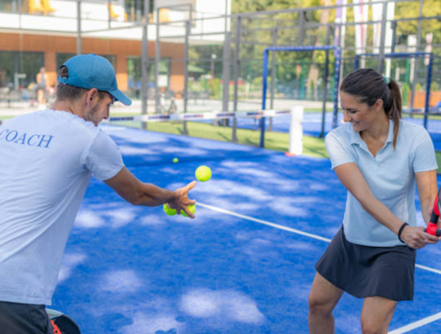 A tennis instructor teaching how to serve during an individual course.